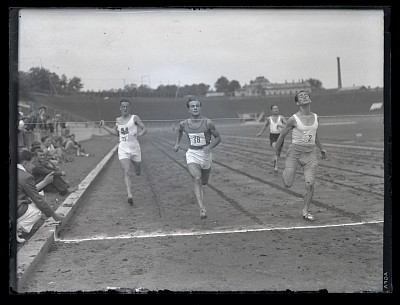 Concurenți într-o cursă de atletism la linia de sosire pe Stadionul O.N.E.F.